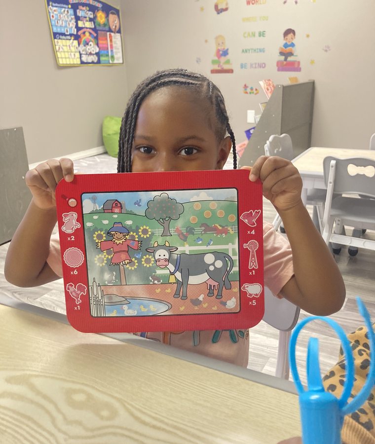 Child showing a completed classroom art activity