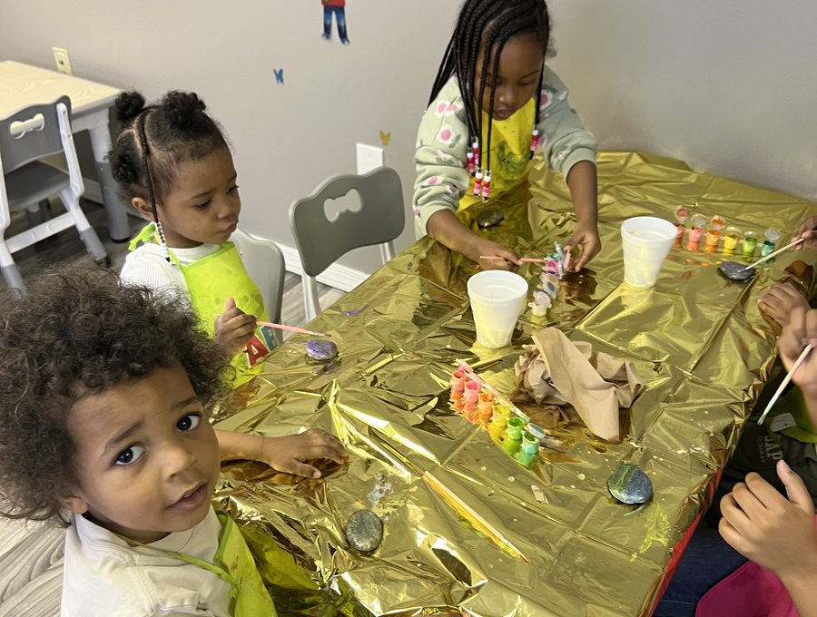 Children painting together at a classroom activity table